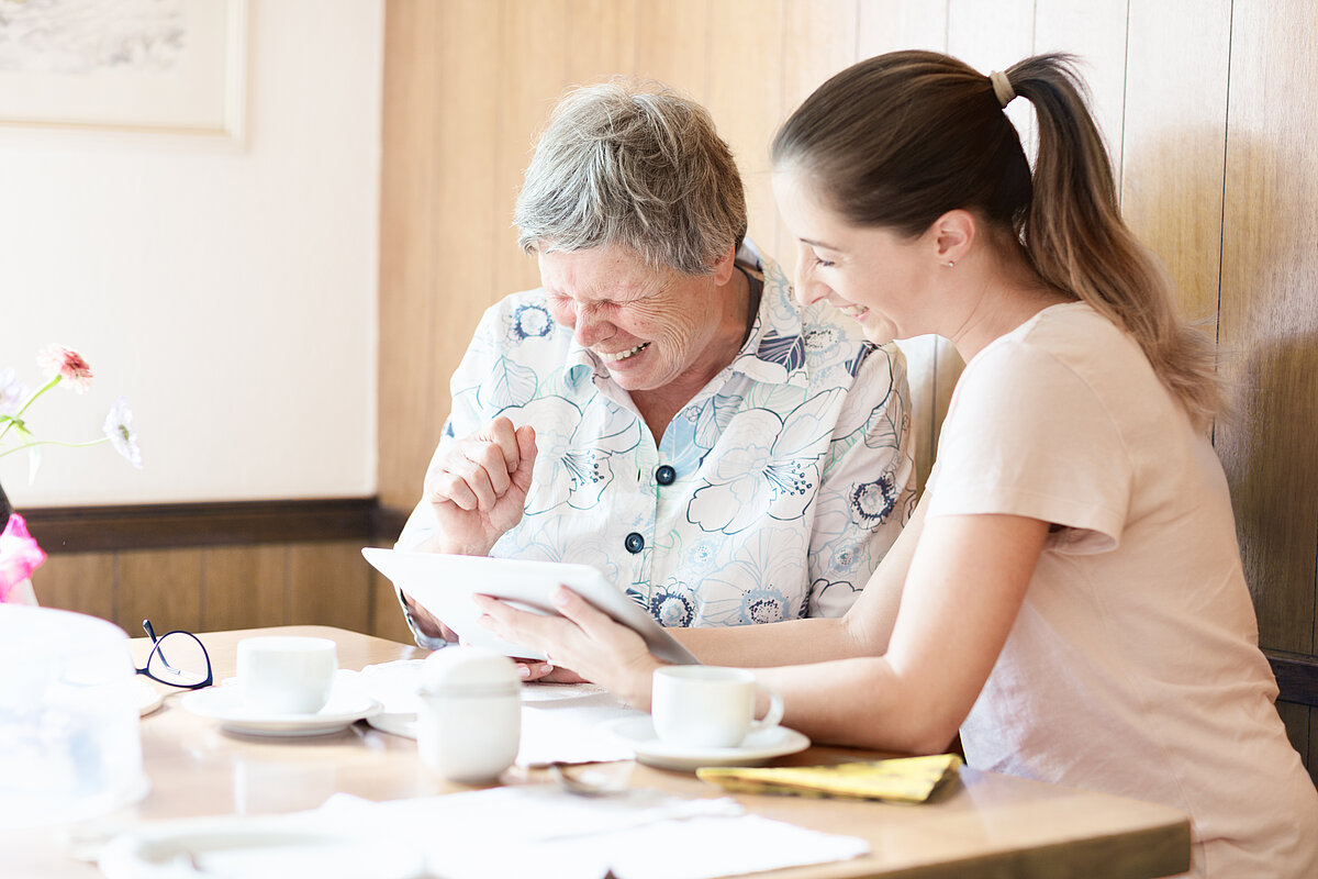 Senior wird ein Tablet erklärt