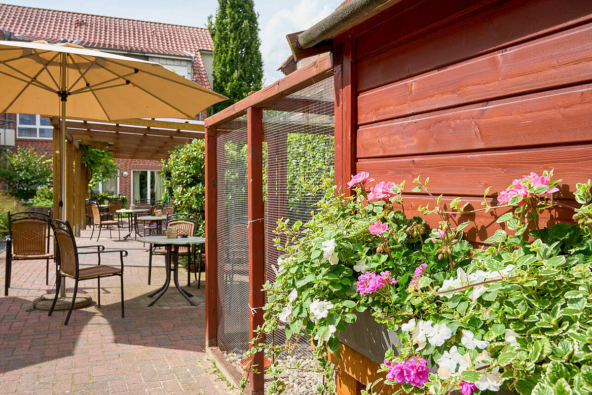 Terasse mit Sonnenschirm und Vogelkäfig im Seniorenheim in Haselünne